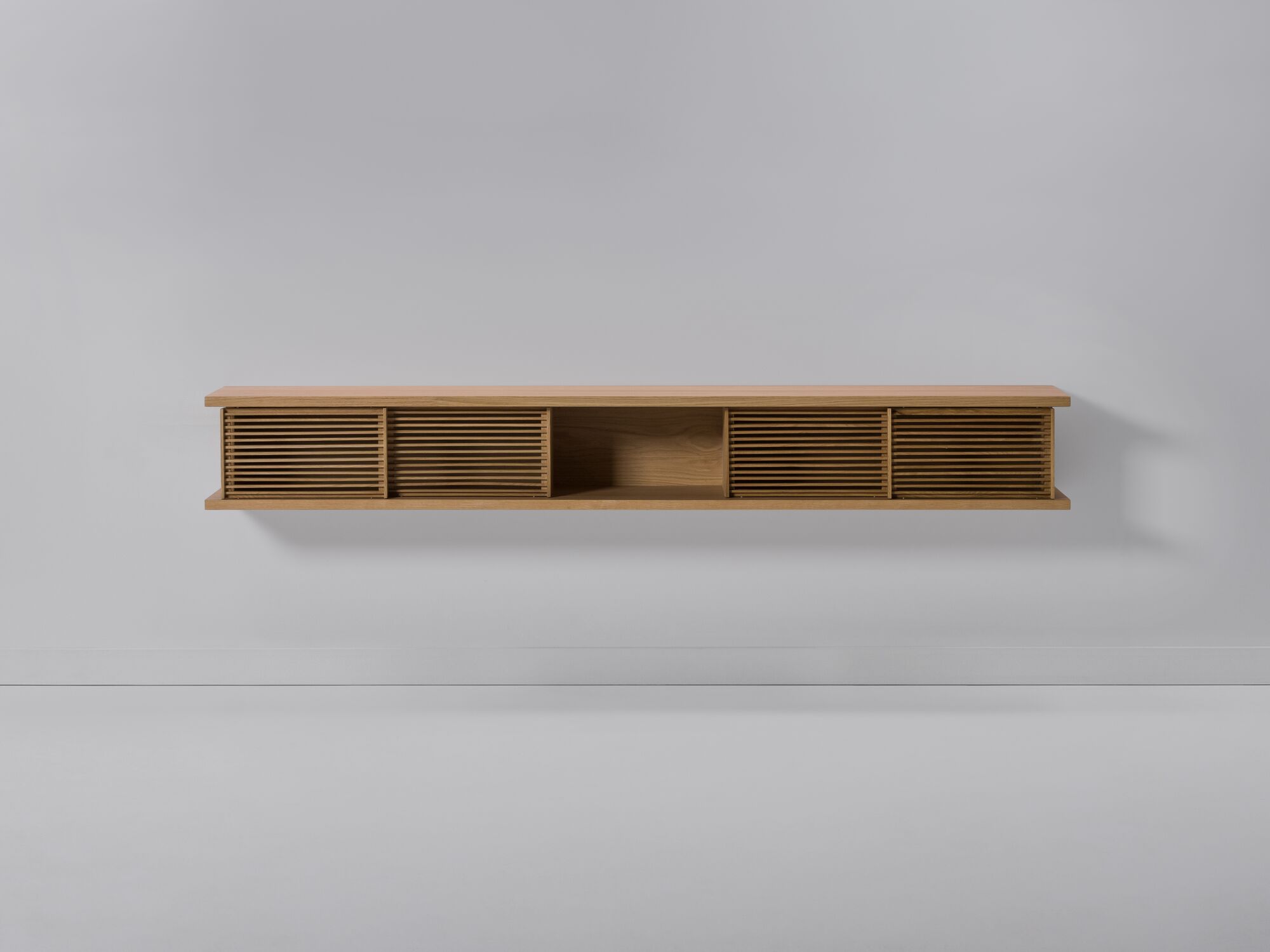 Front view of large oak floating media unit with slatted doors